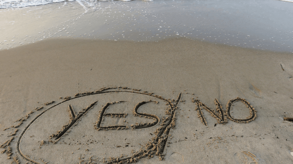 Die Worte Yes und No im Sandstrand geschrieben